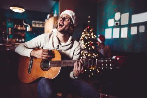 happiness man playing the guitar for christmas at home